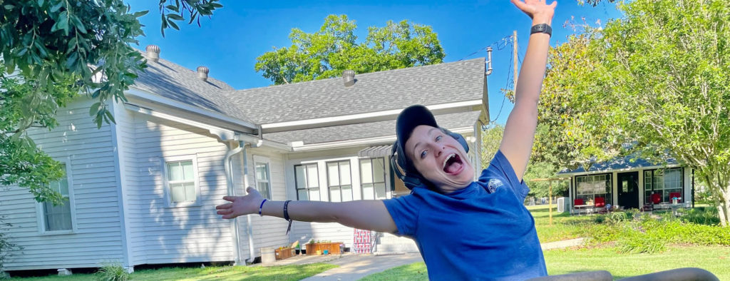 Young woman expressing joy in front of new home.